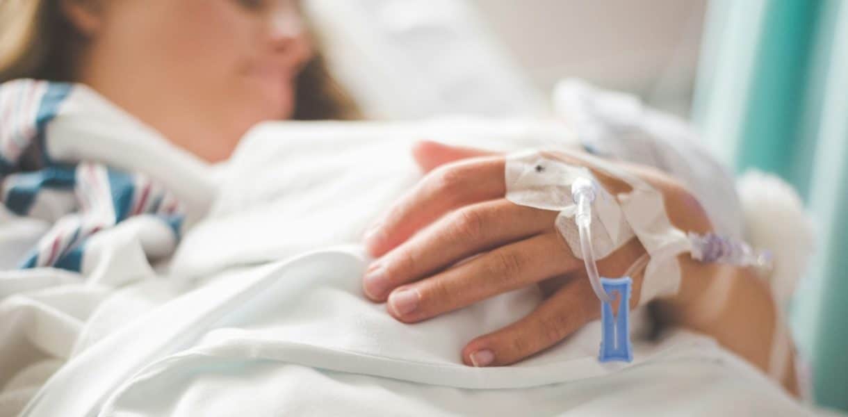 A woman laying in a hospital bed with an iv drip-endocrine disruptors
